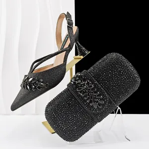 Detailed view of black glitter slingback heels and matching rhinestone clutch bag.