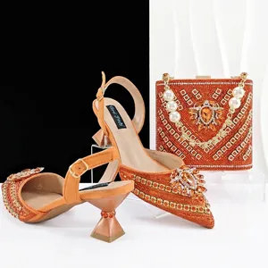 Detailansicht der orangefarbenen Strass-Sandalen und passenden Beuteltasche