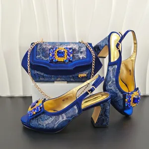 Detailed view of blue snakeskin high heels with matching rhinestone chain bag set