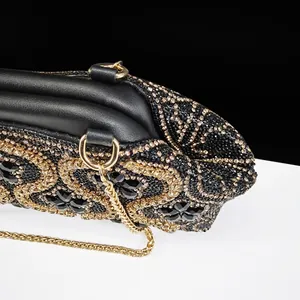Luxury black evening clutch bag with intricate gold rhinestone floral patterns and chain
