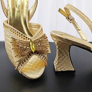 Elegant gold snake pattern chunky heel sandals featuring a large rhinestone bow detail