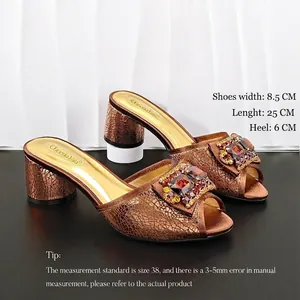Detail view of bronze crackle pattern sandals with rhinestone buckle