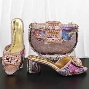 Detail view of matching evening bag and glittery chunky heel mules with large pink rhinestones