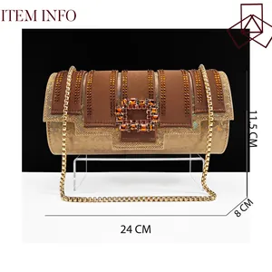 Detail view of a luxury brown and gold cylinder evening bag featuring a rhinestone buckle