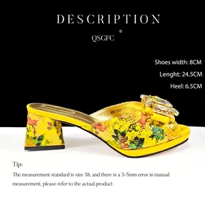 Detailansicht der gelben Pantolette mit Schlangenmuster, Blockabsatz und Strass-Schnalle