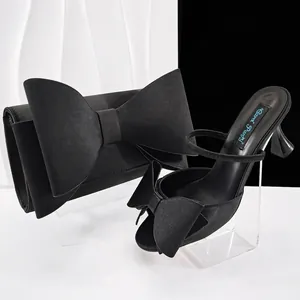 Elegantes Set aus schwarzen Satin-Stilettos mit Schleife und passender Clutch für Damen