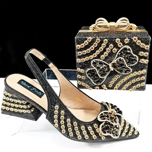 Elegant black shoe and bag set with rhinestone bows and intricate golden chain patterns