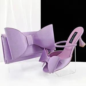 Lila Satin-Pumps mit offener Zehenpartie und passende Clutch mit übergroßer Schleife.