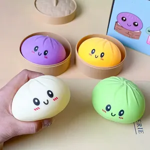 Nahaufnahme einer Hand, die ein weiches weißes Emoji-Squishy-Brötchen fest hält