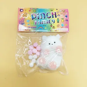 White cat squishy stress relief toy with pink paws in original colorful packaging