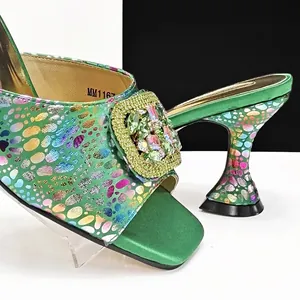 Elegant green square toe mules with sculpted heels and shimmering rhinestone buckle.