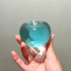 Detailed macro view of a clear blue translucent apple squishy toy held in hand for stress relief