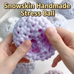 Gros plan de mains pressant une balle anti-stress violette à texture granuleuse
