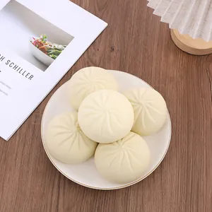 Primo piano di cinque giocattoli antistress realistici a forma di panino su un piatto bianco.