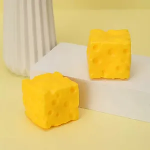 Close-up macro view of two giant bright yellow square cheese squishy toys for stress relief
