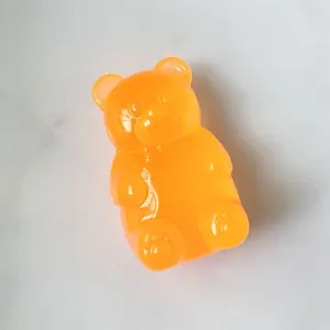 Detalle de un juguete antiestrés naranja translúcido con forma de osito de goma