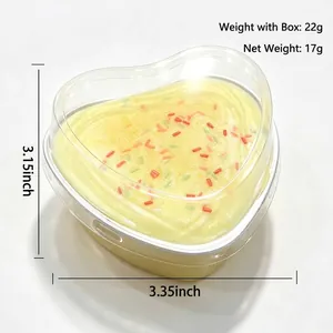 Heart-shaped yellow cake squishy toy with colorful sprinkles in a clear box