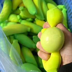 Primer plano de una mano apretando un juguete antiestrés con forma de banana verde.