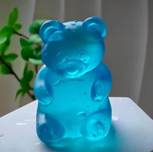 Close-up of a translucent blue gummy bear stress toy with water droplets.