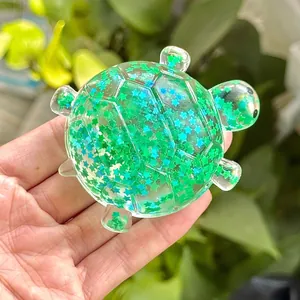 Detailaufnahme eines grünen Schildkröten-Quetschspielzeugs mit Glitzersternen und Gel
