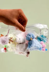 Close-up view of various colorful TPR dog squishy toys in transparent plastic bag