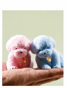 Detail view of pink and blue fluffy puppy squeeze toys held in hand for stress relief