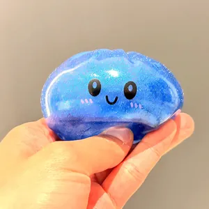 Primo piano di una mano che preme un giocattolo antistress blu glitterato a forma di panino