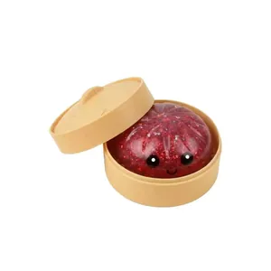 Roter Glitzer-Quetsch-Dampfbrötchen-Spielzeug in einem Miniatur-Dampfkorb Detailansicht