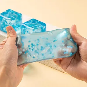 Gros plan d'un jouet anti-stress cube de glace bleu avec flocons de neige étiré à la main.