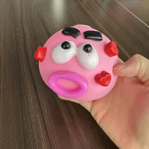 Detailed view of the pink Smushers funny face squishy stress ball held in hand