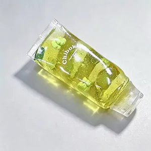 Transparenter Zahnpasta-Squishy mit gelbem Gel und kleinen grünen Blumeneinsätzen
