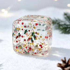 Detailed view of transparent Christmas squishy toy filled with festive glitter stars.
