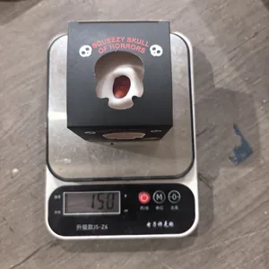 Jouet de décompression tête de mort d'Halloween sur balance numérique pesant 150g