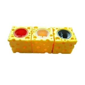 Vista detallada de tres juguetes para apretar con forma de queso amarillo y centros de colores