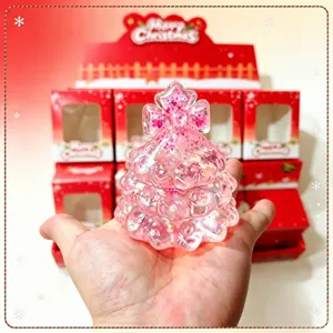 Detailed view of a pink sequin Christmas tree squishy toy held in hand showing texture.