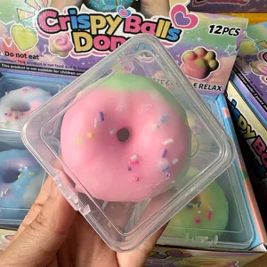 Close-up of a pink and green donut stress relief squishy toy in a clear square container