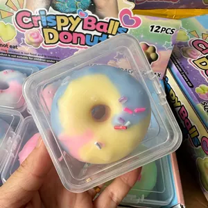 Macro shot of a colorful donut squishy toy in clear plastic box packaging.