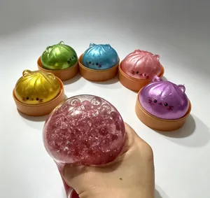 Λεπτομέρεια από διάφορα πολύχρωμα squishy γατάκια και χέρι που πιέζει ένα μοντέλο με χάντρες