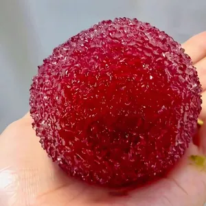 Primer plano detallado de la textura realista de madroño en un juguete antiestrés rojo.