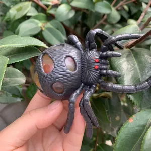 Detailansicht eines schwarzen Halloween-Spinne-Quetschspielzeugs mit buntem Traubenball