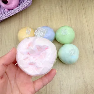 Detail view of a handmade gradient crunchy ball stress relief toy held in hand.