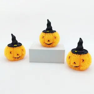 Nahaufnahme von drei flauschigen orangefarbenen Halloween-Kürbis-Fidget-Toys mit Hüten