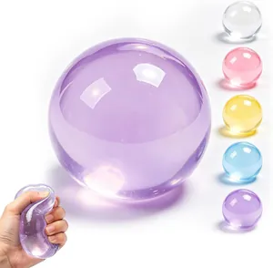 Gros plan d'une balle anti-stress violette translucide pressée par une main humaine