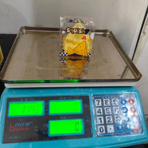 Vue détaillée montrant le poids de 114g d'un jouet squishy fromage jaune sur une balance.