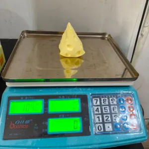 Vue détaillée montrant le poids de 104g de ce jouet squishy en forme de fromage.