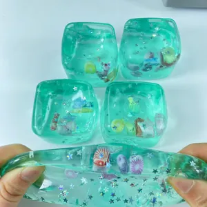 Cubo antiestrés de temática oceánica verde azulado con conchas y purpurina