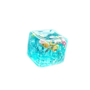 Juguete sensorial cubo blandito estilo océano 5,5cm con conchas y estrellas de brillo