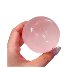 Hand hält einen rosa transparenten Kirschblüten-Squishy-Ball zur Stressbewältigung.