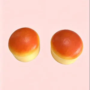 Detailed view of two realistic mini bread rolls slow-rebound squishy toys on pink background