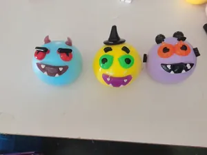 Gros plan de trois jouets à presser en forme de monstres d'Halloween colorés.
